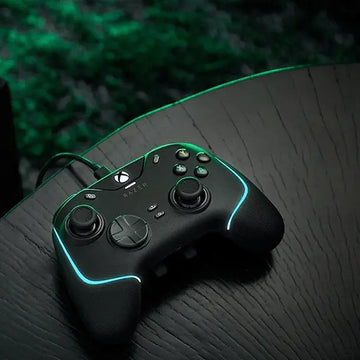 Black gaming controller with green accents on a dark surface